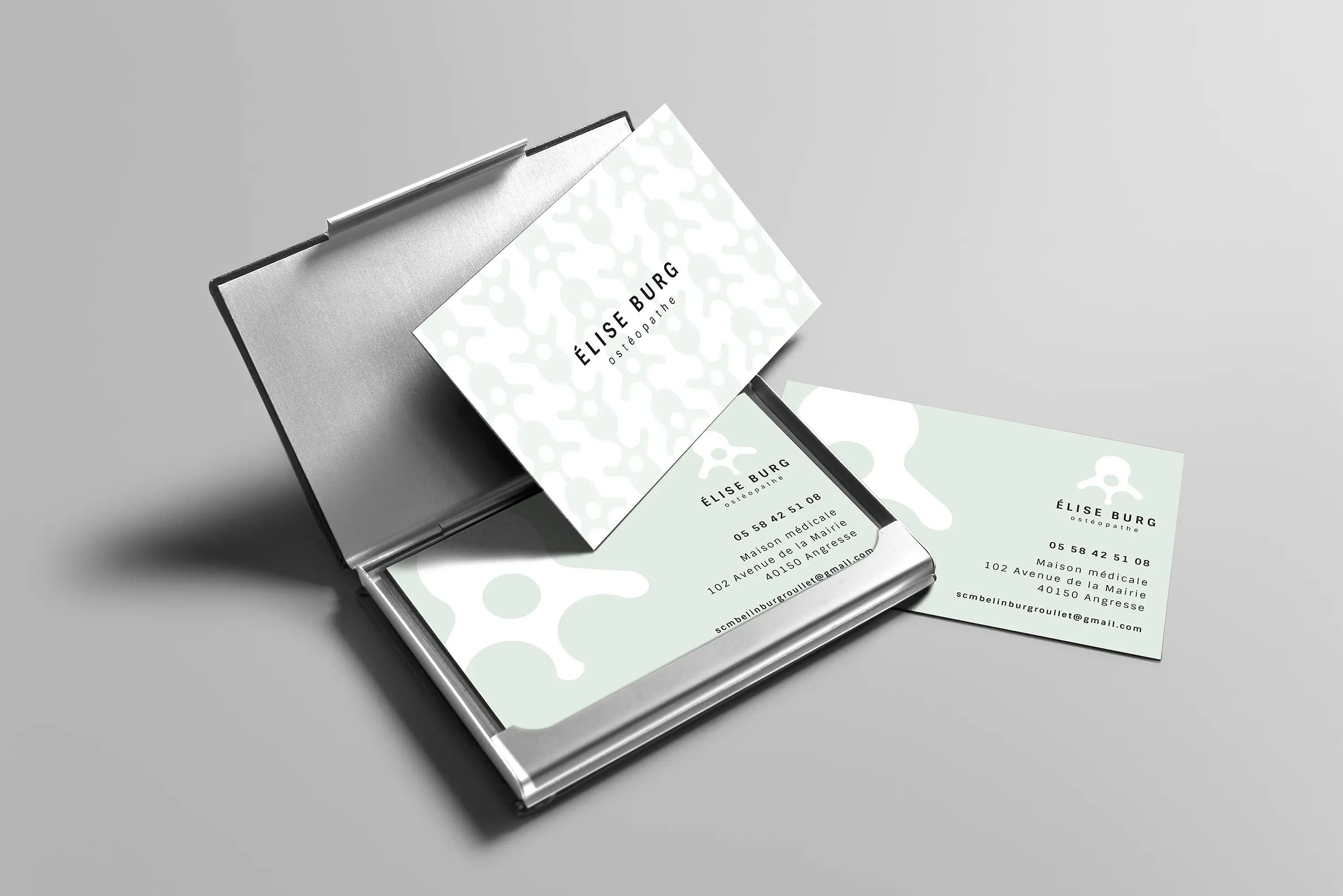 Cartes de visite de l'ostéopathe mettant en avant son logo composé d'une typographie linéale, accompagné d'un motif stylisé représentant une vertèbre.